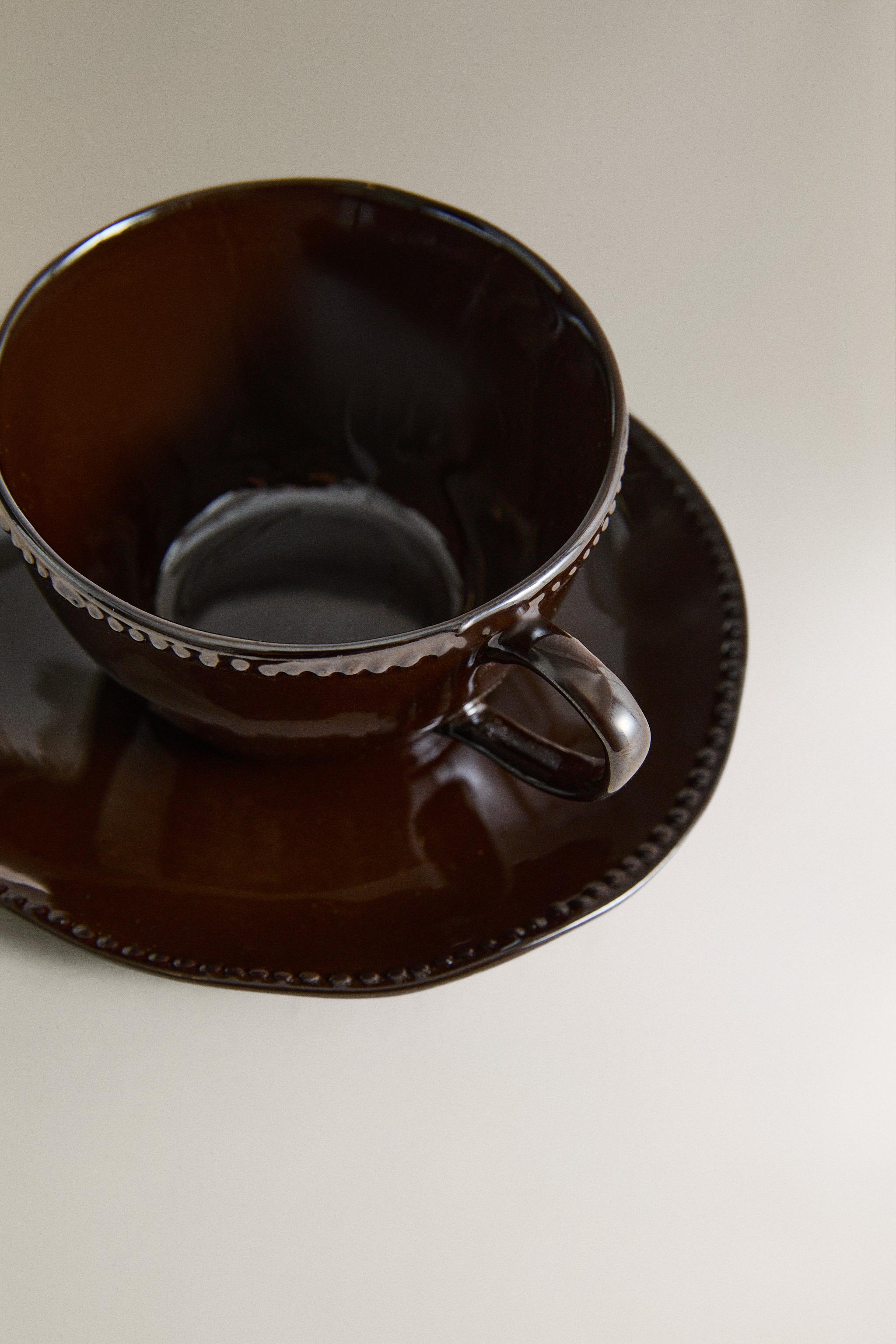 STONEWARE COFFEE CUP AND SAUCER WITH RAISED DESIGN